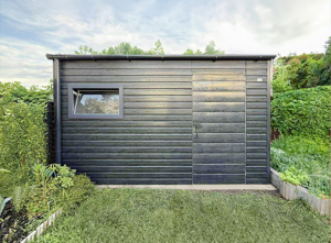 4x2m-es prémium kerti tároló előre lejtő tetővel, +30cm emeléssel, filcbevonattal, fahatású antracitszürke színben, ajtóval, ablakkal, szegélyekkel, ereszcsatornával