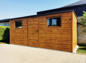 5,1×1,7m-es fém kerti tároló hátra lejtő tetővel, világos aranytölgy falakkal és ajtóval, 2db ablakkal, csokoládébarna tetővel, szegélyekkel, horganyzott vázszerkezettel, vízszintes lemezborítással